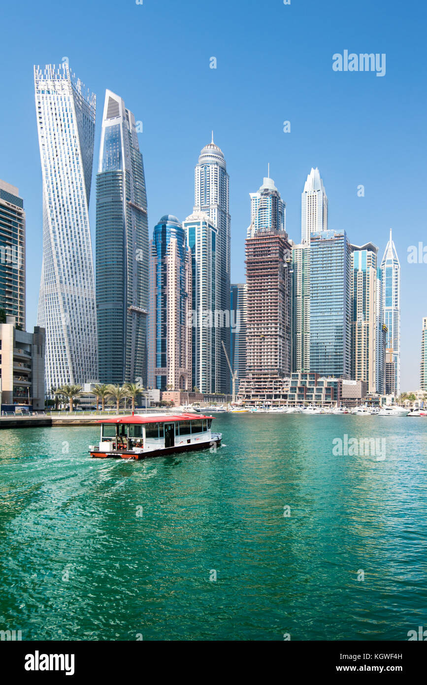 DUBAI, UAE - 31OCT2017: A Water Bus moving towards the Iconic towers of Dubai Marina including (l-r) Cayan, Damac Heights, Marriott, Emirates Crown, P Stock Photo