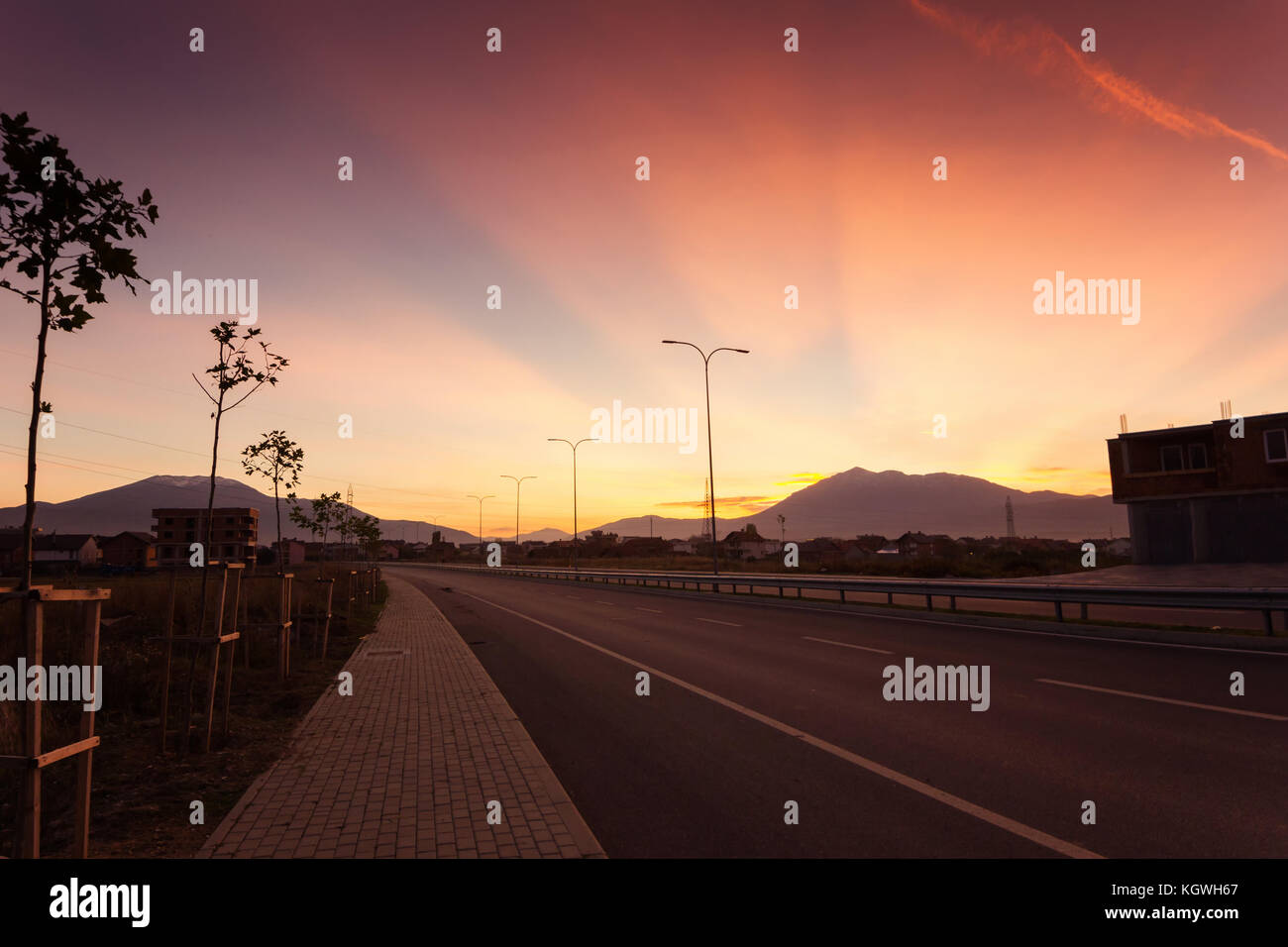 empty highway road in a city of Kosovo in sunset light Stock Photo