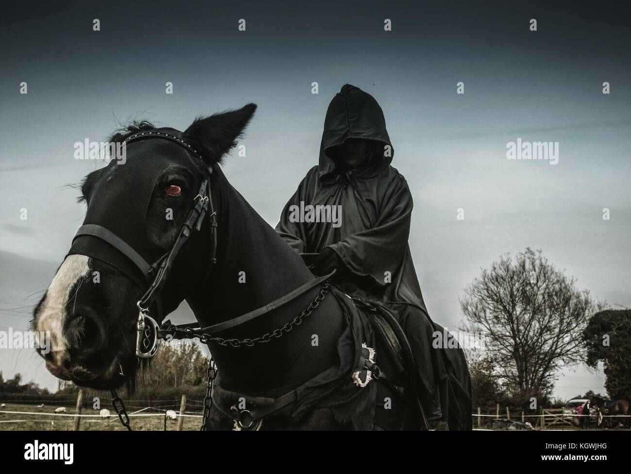 Hooded figure on horse back Stock Photo