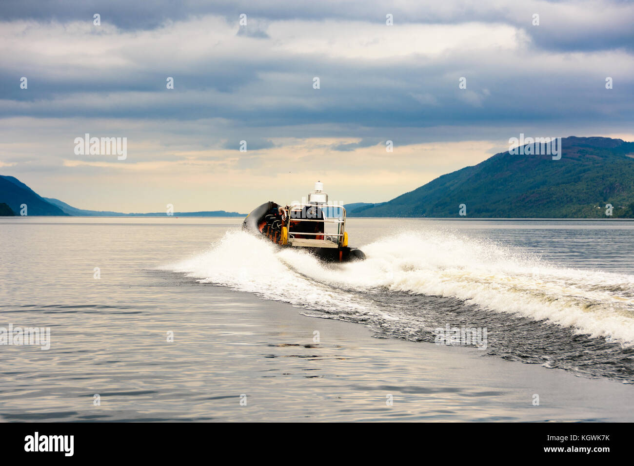 Tourists speedboating on a RIB boat (perhaps hoping to find Nessie the Loch Ness Monster) on the iconic Loch Ness, Scotland Stock Photo