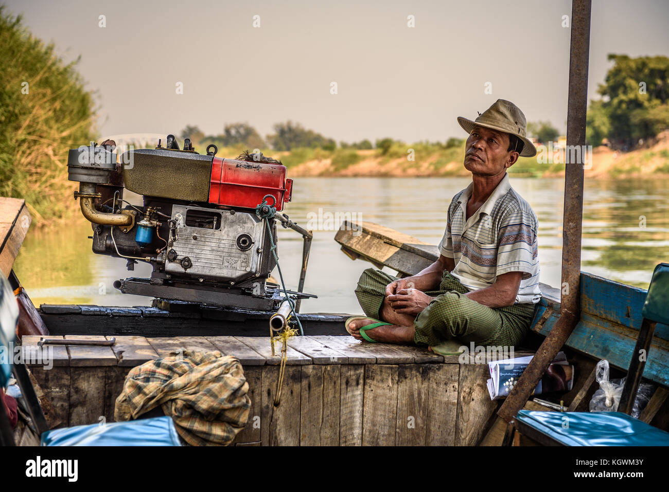 Burmese man controls a boat for travel the Mu River Stock Photo