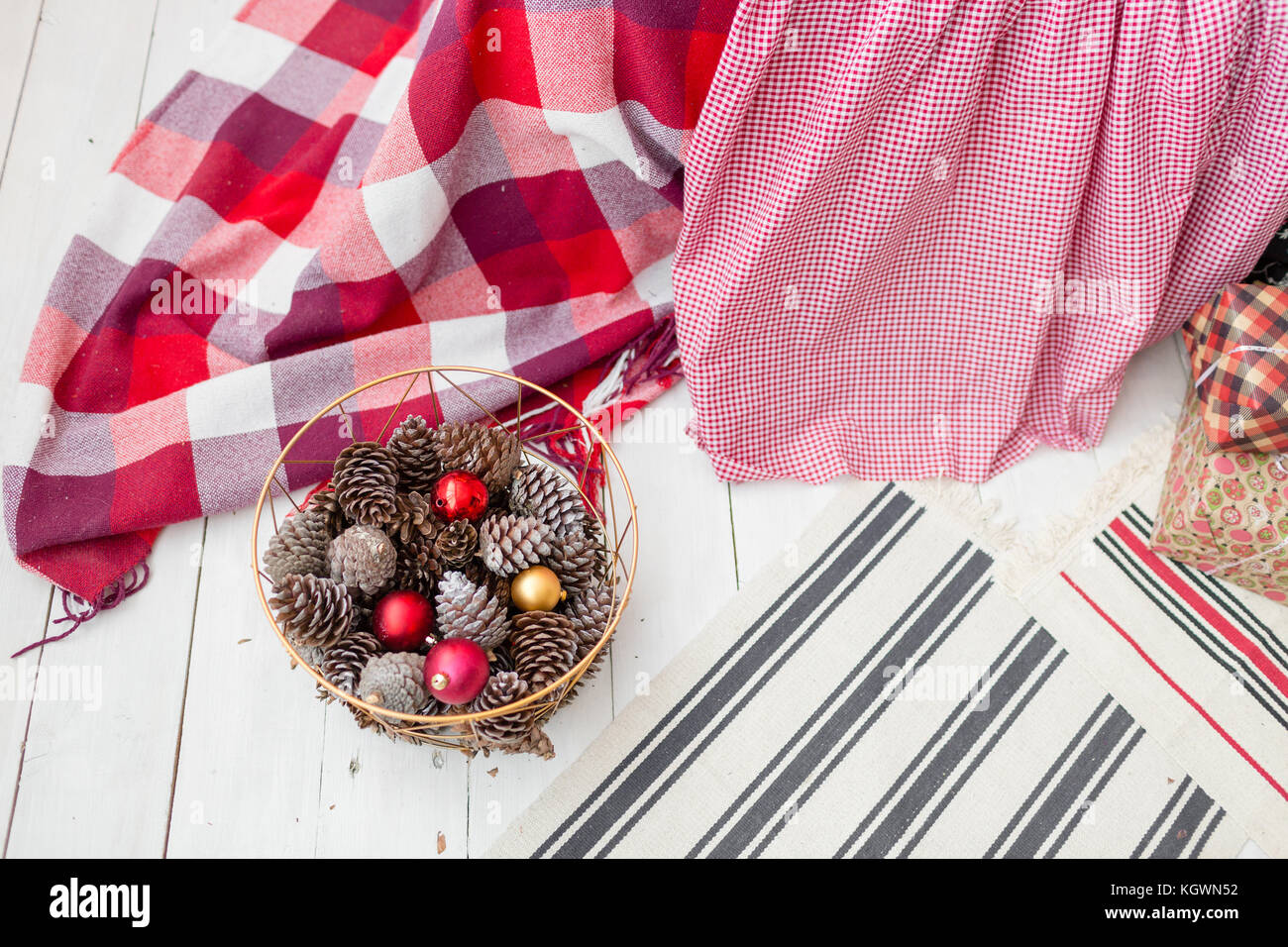 Christmas decorations in basket and pine cones on floor close up Stock ...