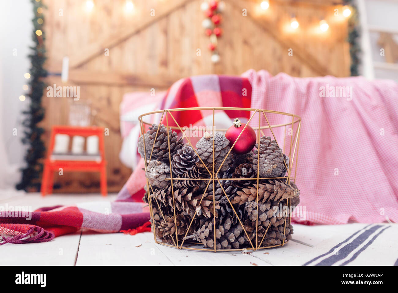 Christmas decorations in basket and pine cones on floor close up Stock ...