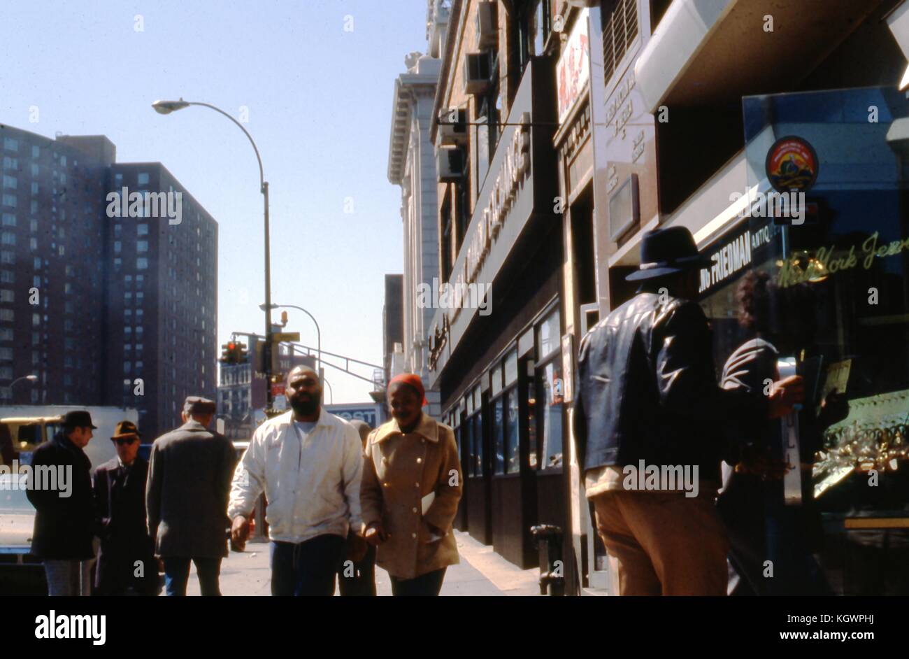 View facing southwest of the corner of Canal Street and The Bowery, in the Chinatown neighborhood of Manhattan, New York City, April, 1979. An African American man and woman walk north on the sidewalk past the New York Jewelry Exchange at 70-74 Bowery. () Stock Photo