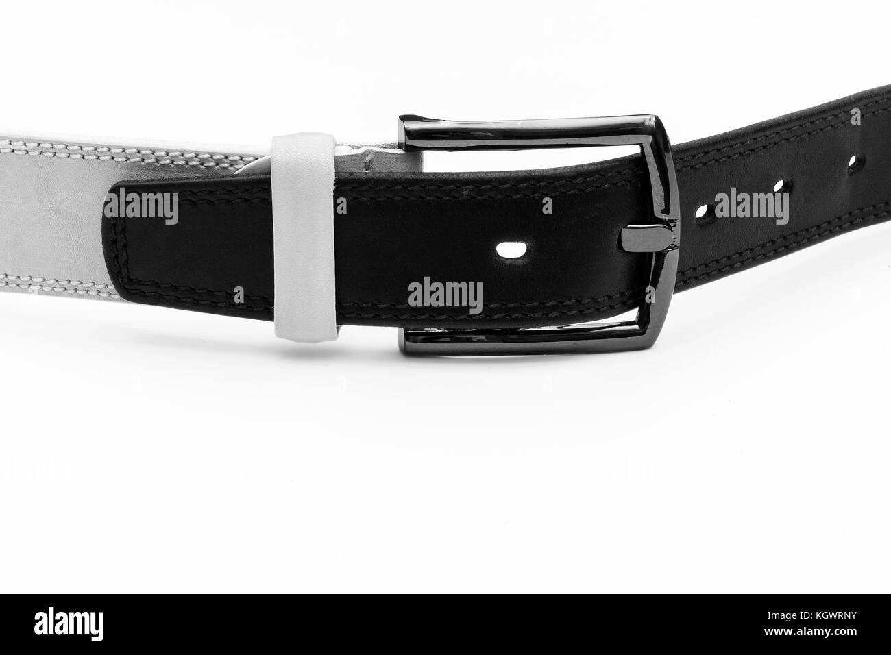Black leather belt is inserted into the buckle of the white belt on a