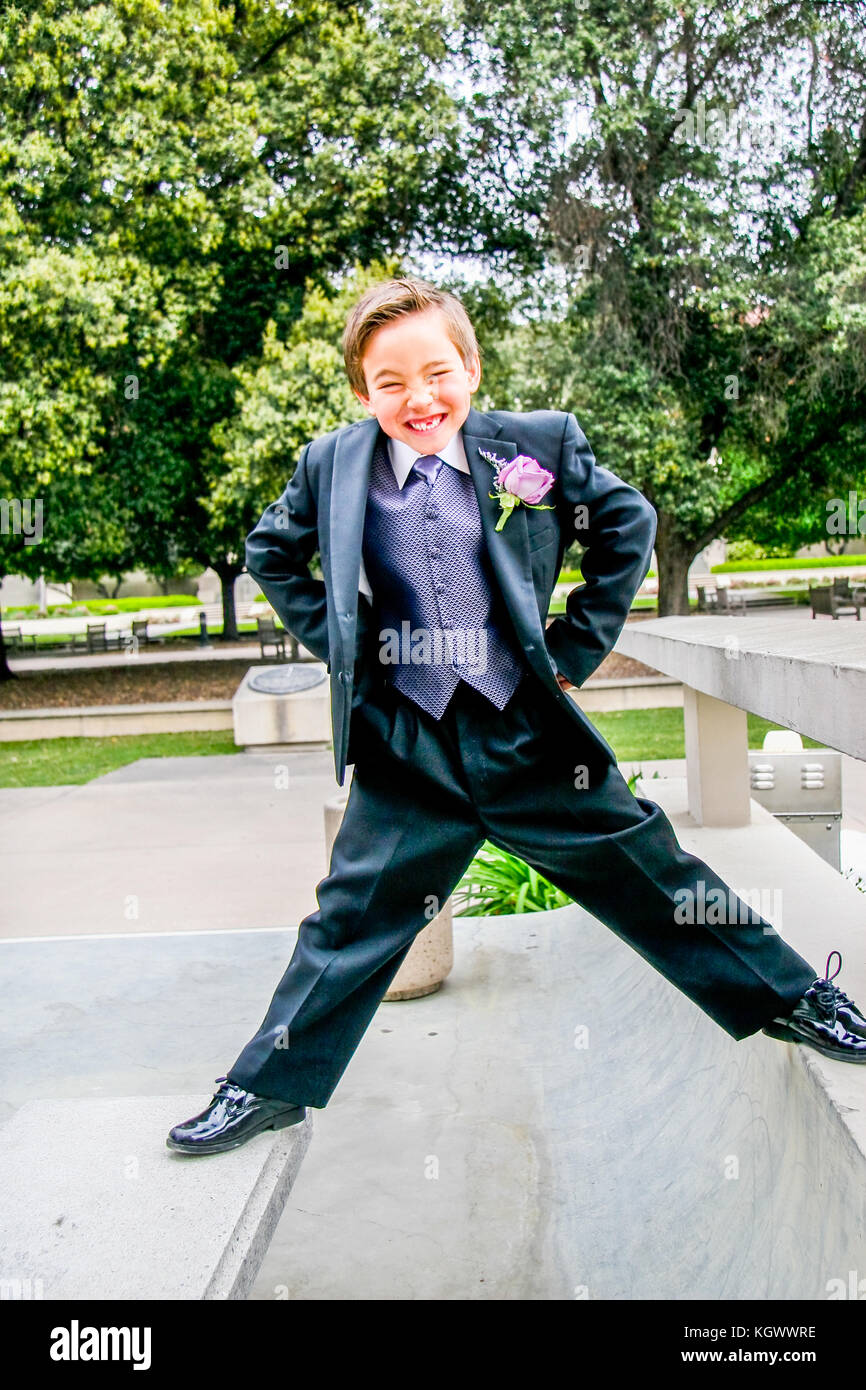 A young ring bearer boy in tuxedo making funny face before wedding