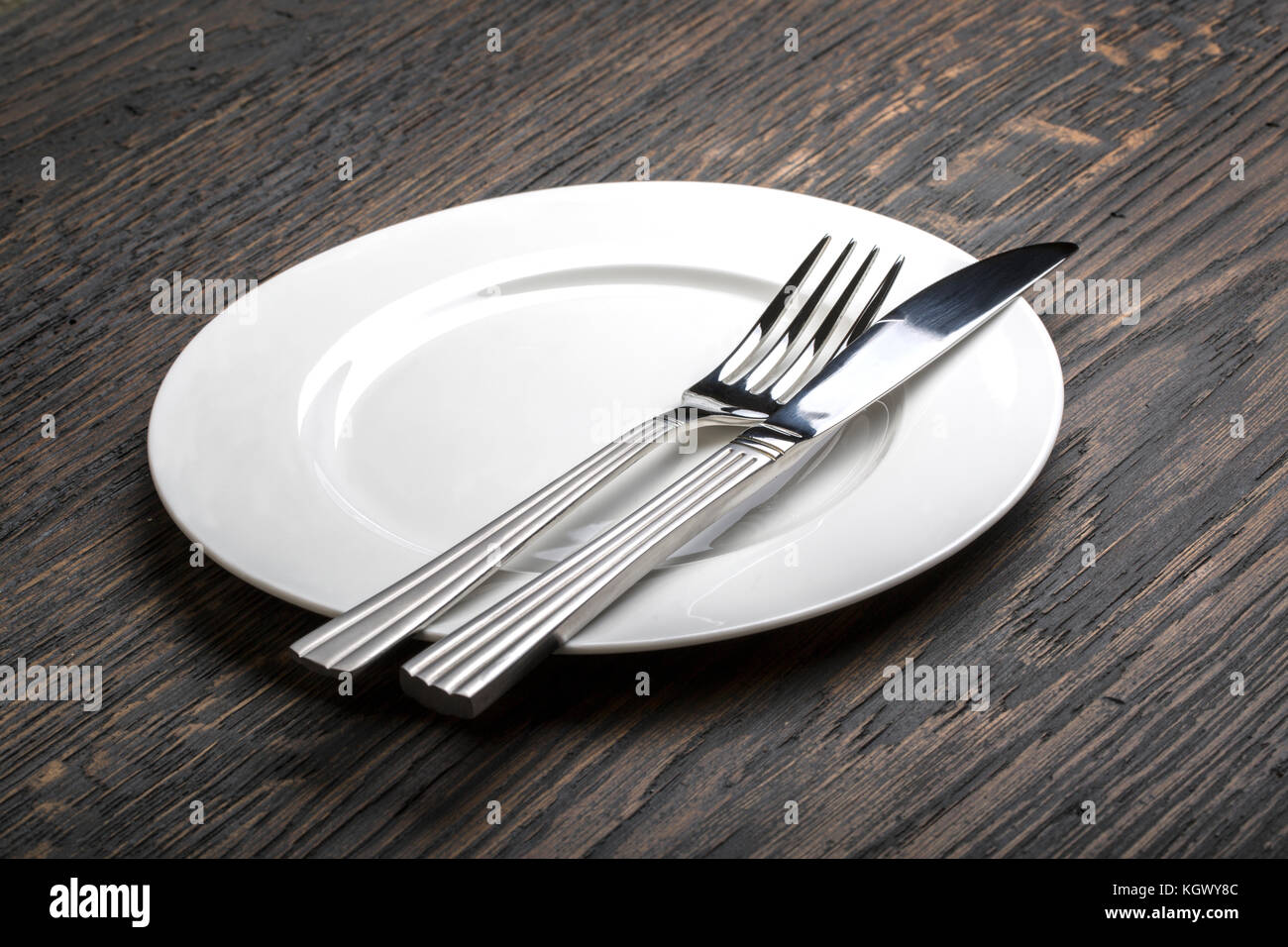table setting. empty white plate with knife and fork Stock Photo - Alamy