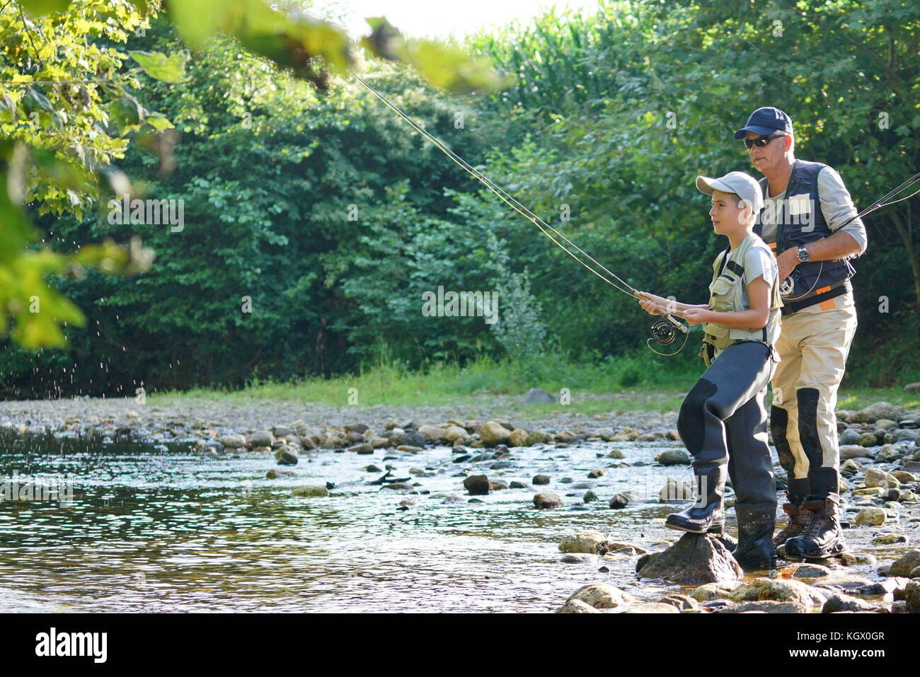 Father teaching son how to fly-fish in river Stock Photo - Alamy