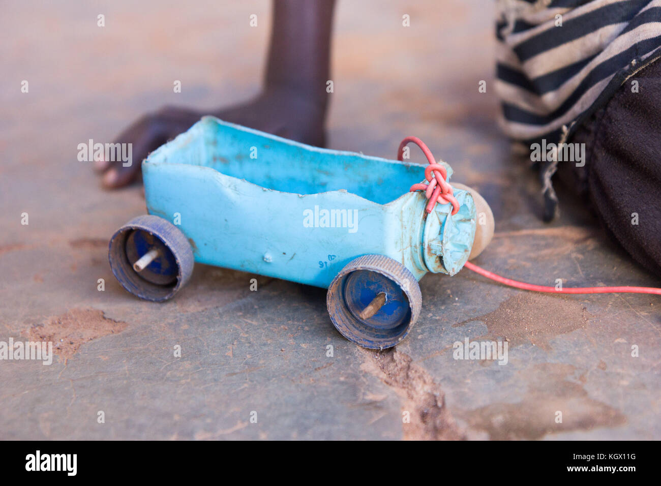 A simple toy car made of a plastic box, bottle caps and skewer sticks. Photo taken in Najja, Uganda on 9 May 2017. Stock Photo