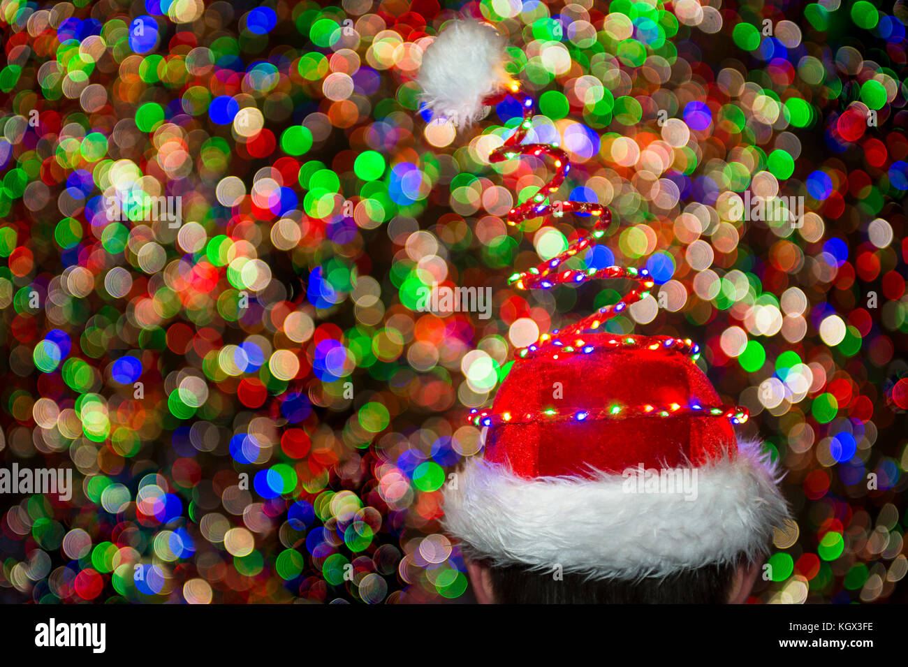 Colorful holiday lights glow on a Santa hat in front of a twinkling