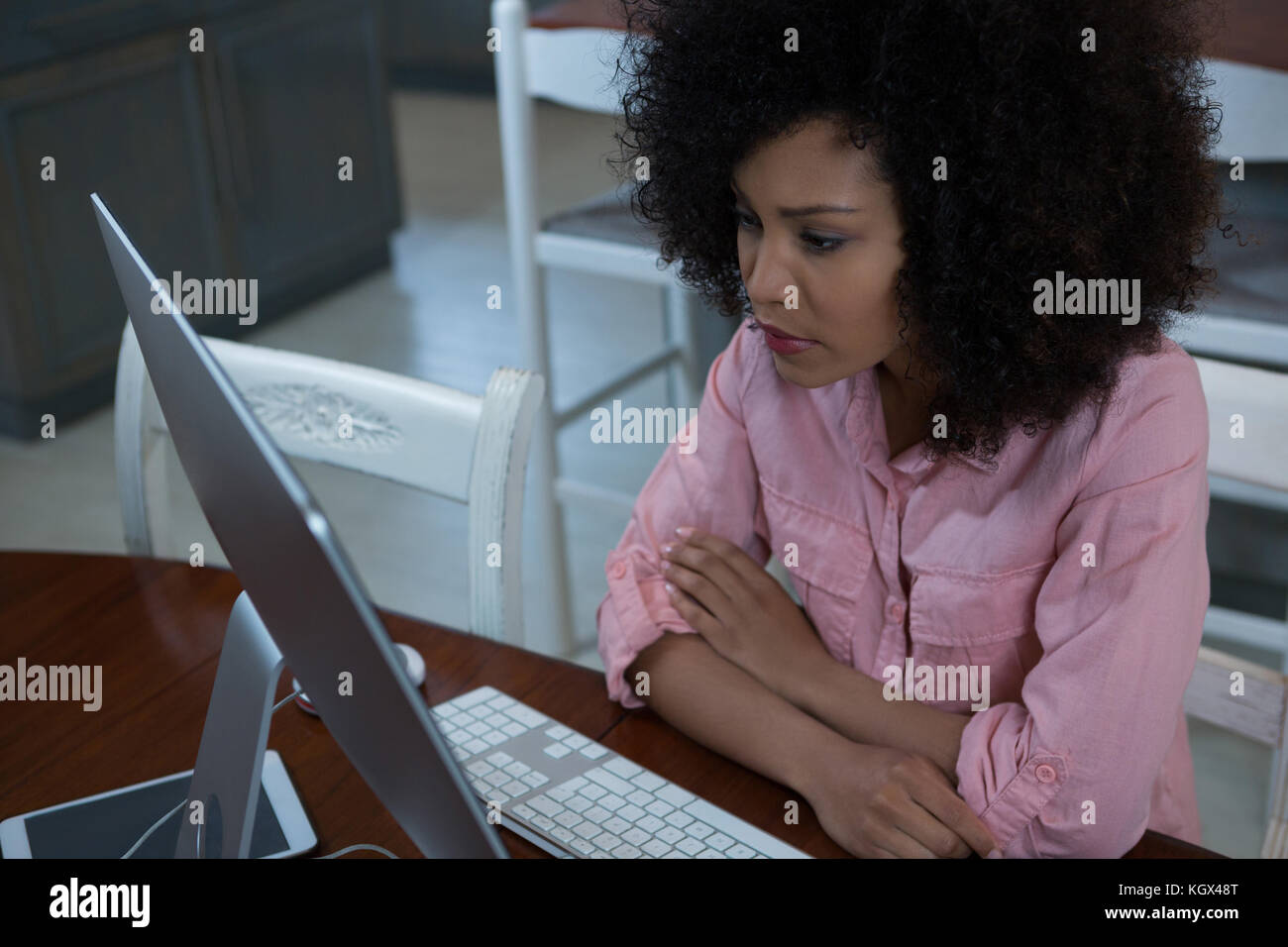 Young woman using computer at home Stock Photo