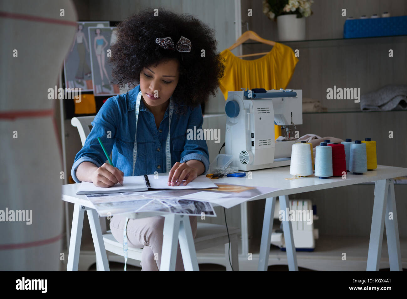 Female fashion designer working at desk in home Stock Photo - Alamy