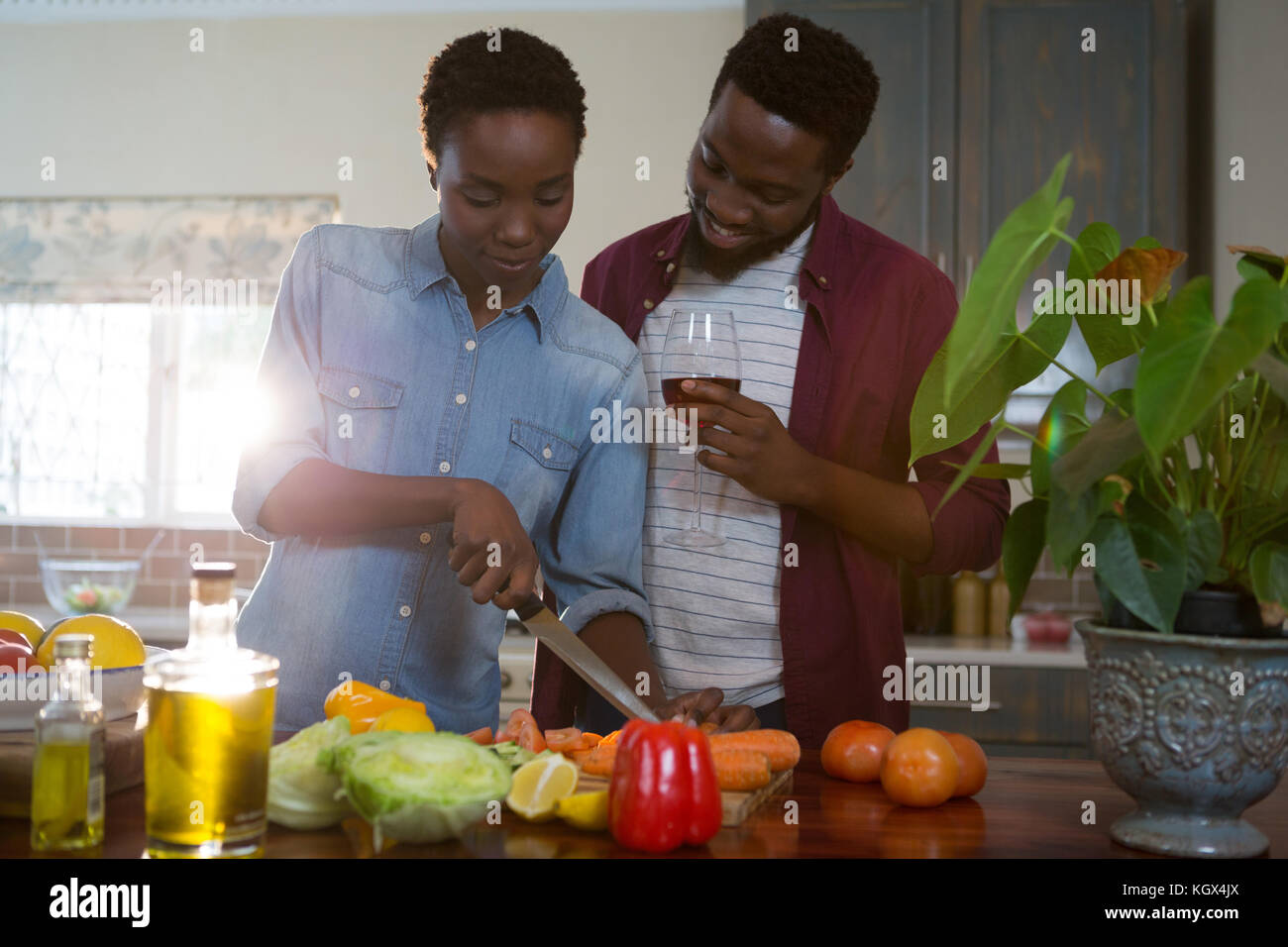 Couple having wine while chopping vegetables in kitchen Stock Photo Alamy