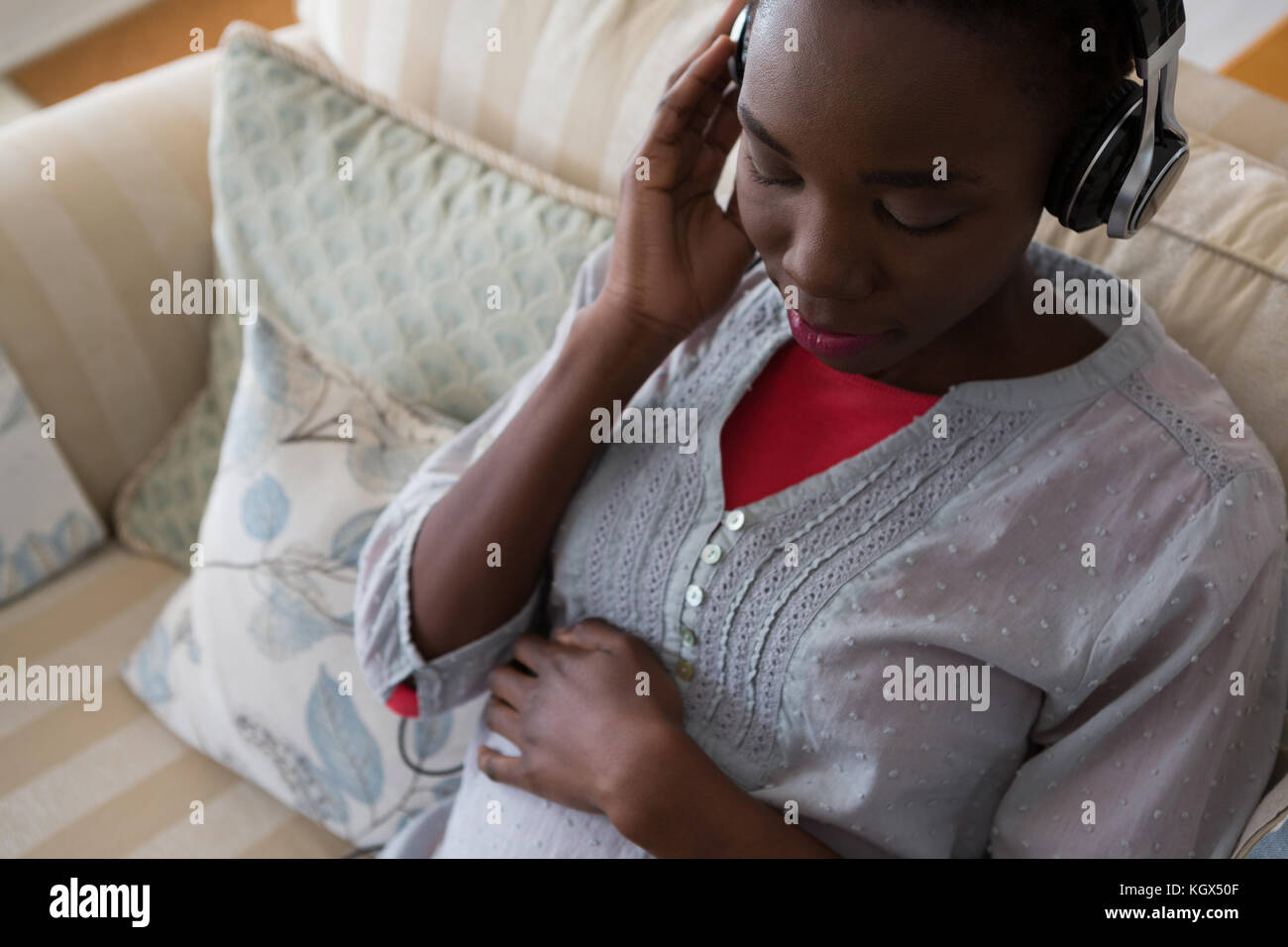Pregnant woman listening music on headphones at home Stock Photo - Alamy