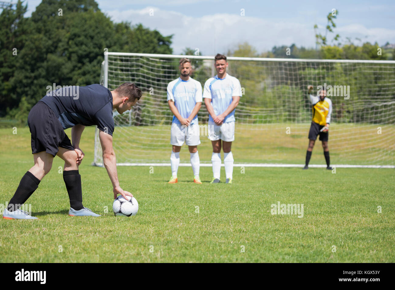 Soccer player is ready to kick ball from penalty spot in the ground