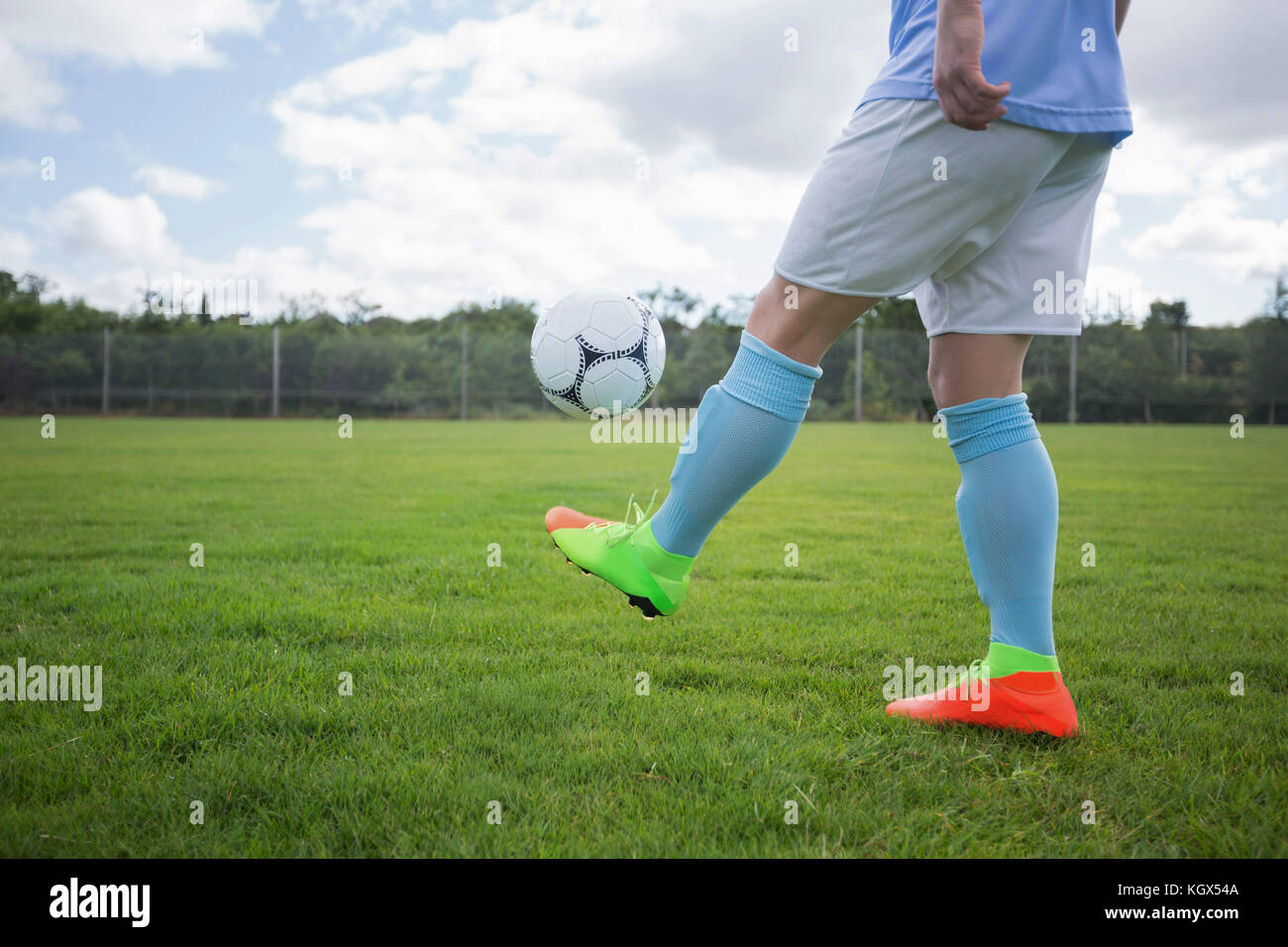 Football player juggling soccer ball in the ground Stock Photo Alamy