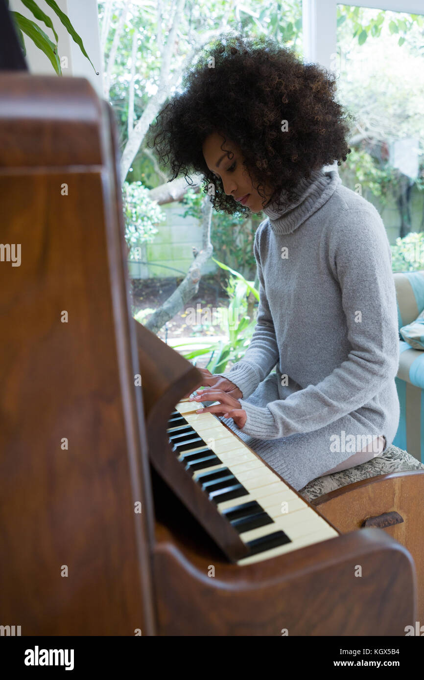 Beautiful woman playing piano at home Stock Photo - Alamy