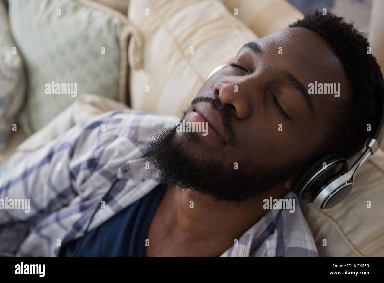 Man sleeping while listening to music at home Stock Photo
