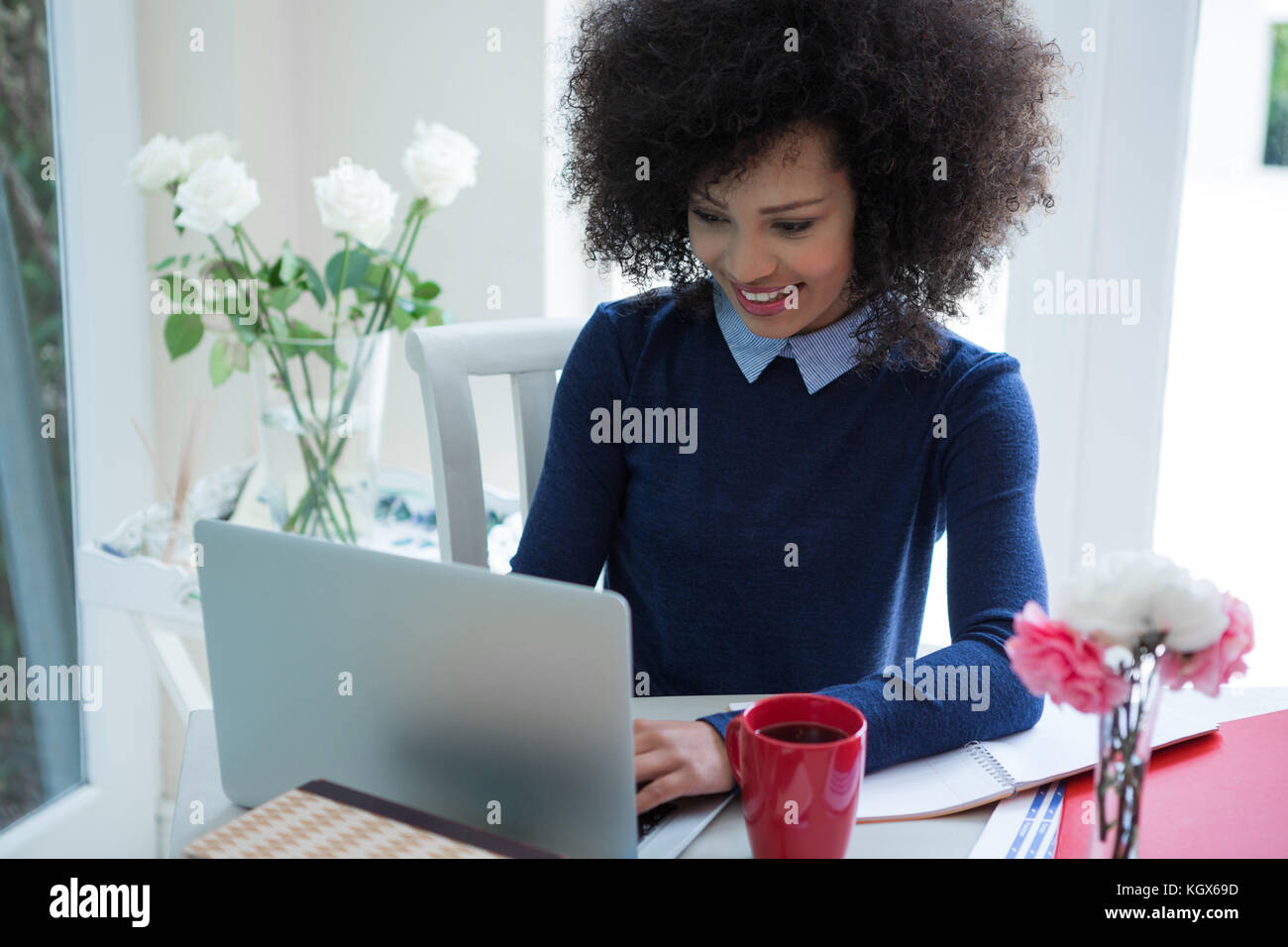 Beautiful woman using laptop at desk in home Stock Photo - Alamy