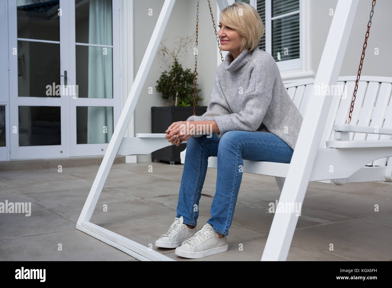 Woman on porch swing hi-res stock photography and images - Alamy