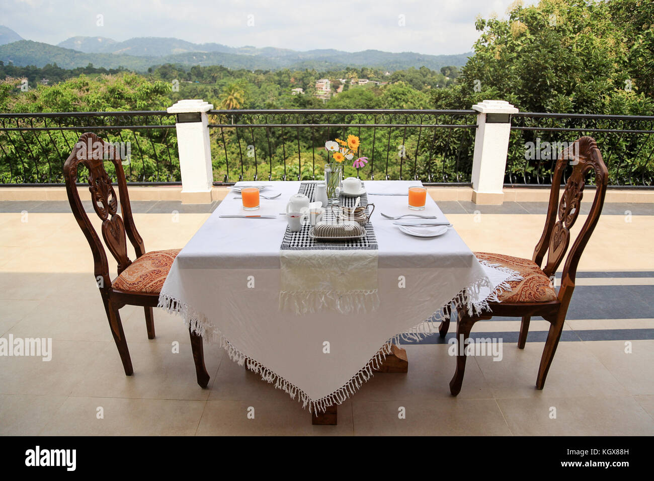 Breakfast table covered with white cloth, prepared for breakfast, outdoor  on balcony with a view on the green nature in Sri Lanka Stock Photo - Alamy