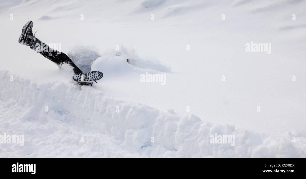 Man is falling headfirst into deep snow. Concept of winterly slippery conditions. Stock Photo