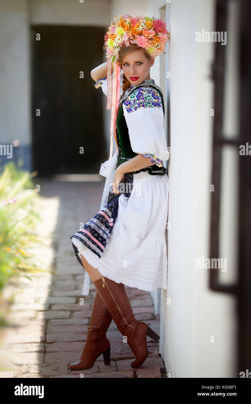 Woman dressed in slovak folk dress standing outdoor leaning towards a  traditional old style house wall Stock Photo - Alamy