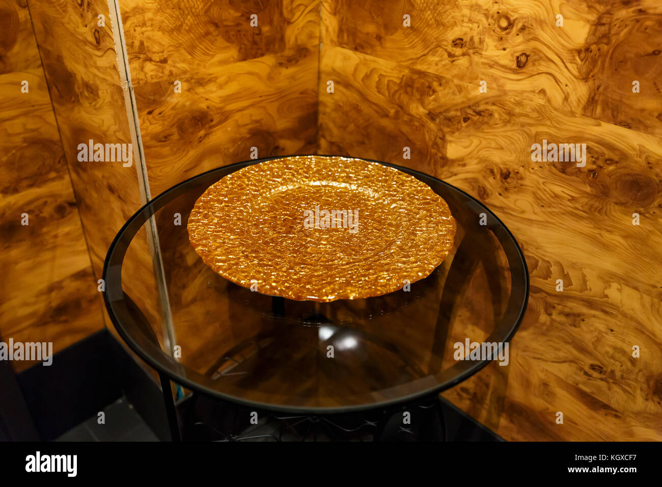 the gold plate on the transparent glass table Stock Photo