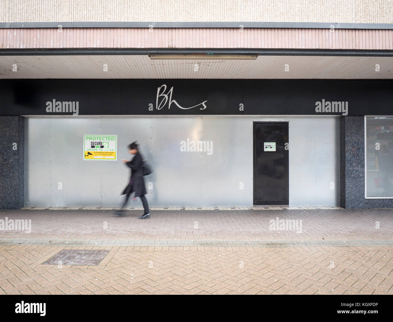 The closed BHS or British Home Stores Shop in Stevenage Hertfordshire UK with a person walking past in front with motion blur Stock Photo