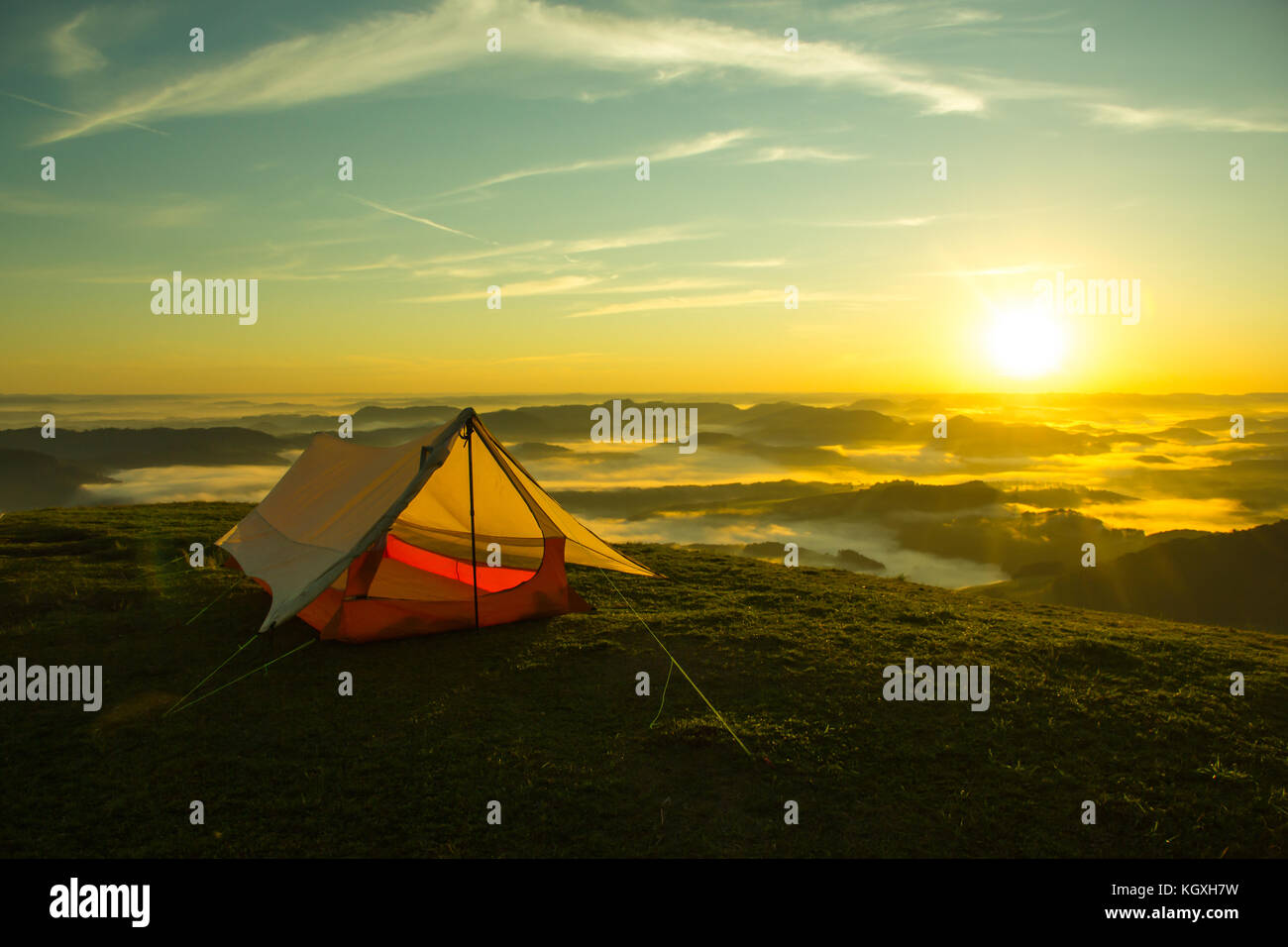 Simple Tent on the Top of a green mountain with the Sunrise Stock Photo ...
