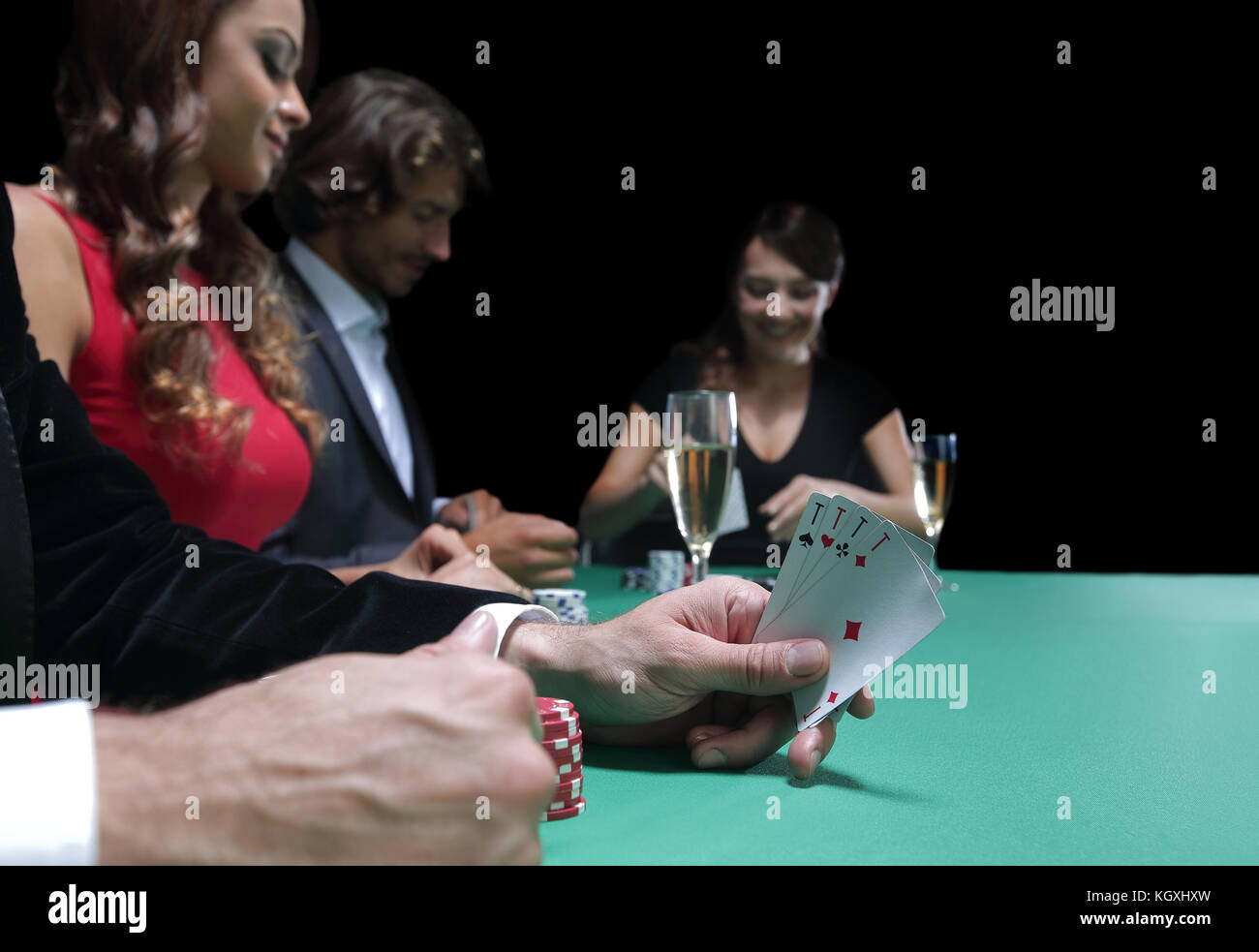 Poker chips and a hand flip the cards isolated against green felt Stock