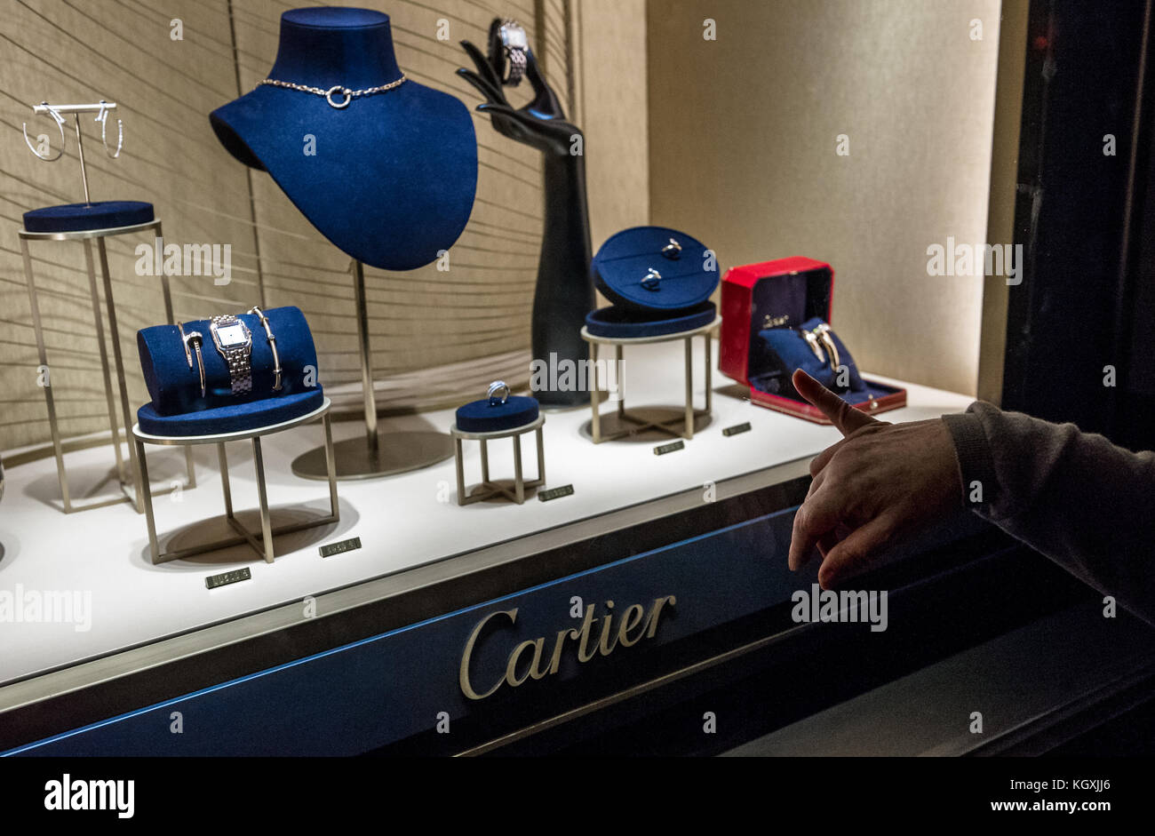 Woman's finger pointing at expensive jewellery in a Cartier shop window. Stock Photo