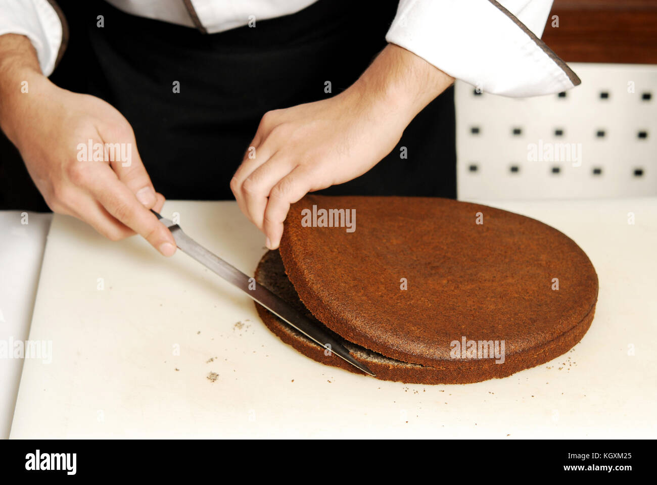 Male chef preparing cake on the kitchen board Stock Photo