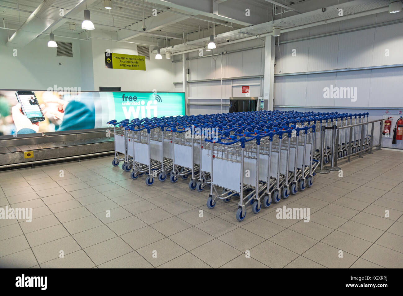 Luggage or baggage  trolleys by a baggage or luggage reclaim carousel at Belfast City Airport. Stock Photo