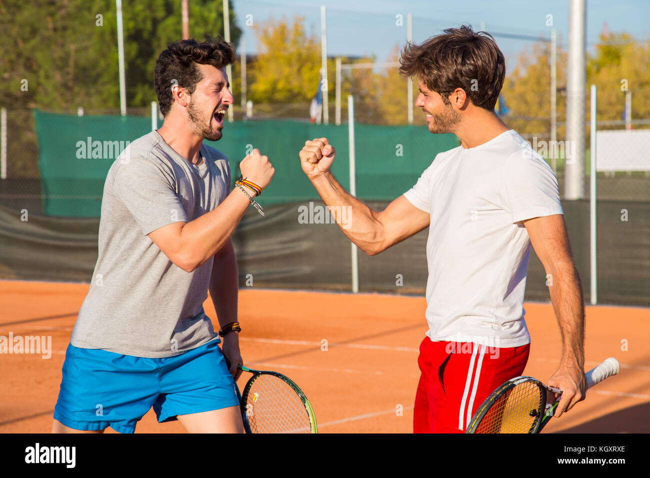 Two friends standing on tennis court and encouraging each other before  match Stock Photo - Alamy