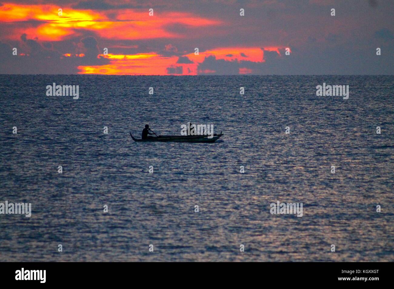 Silhouette of a fisherman in a boat off the coast of Siquijor Island Philippines Stock Photo