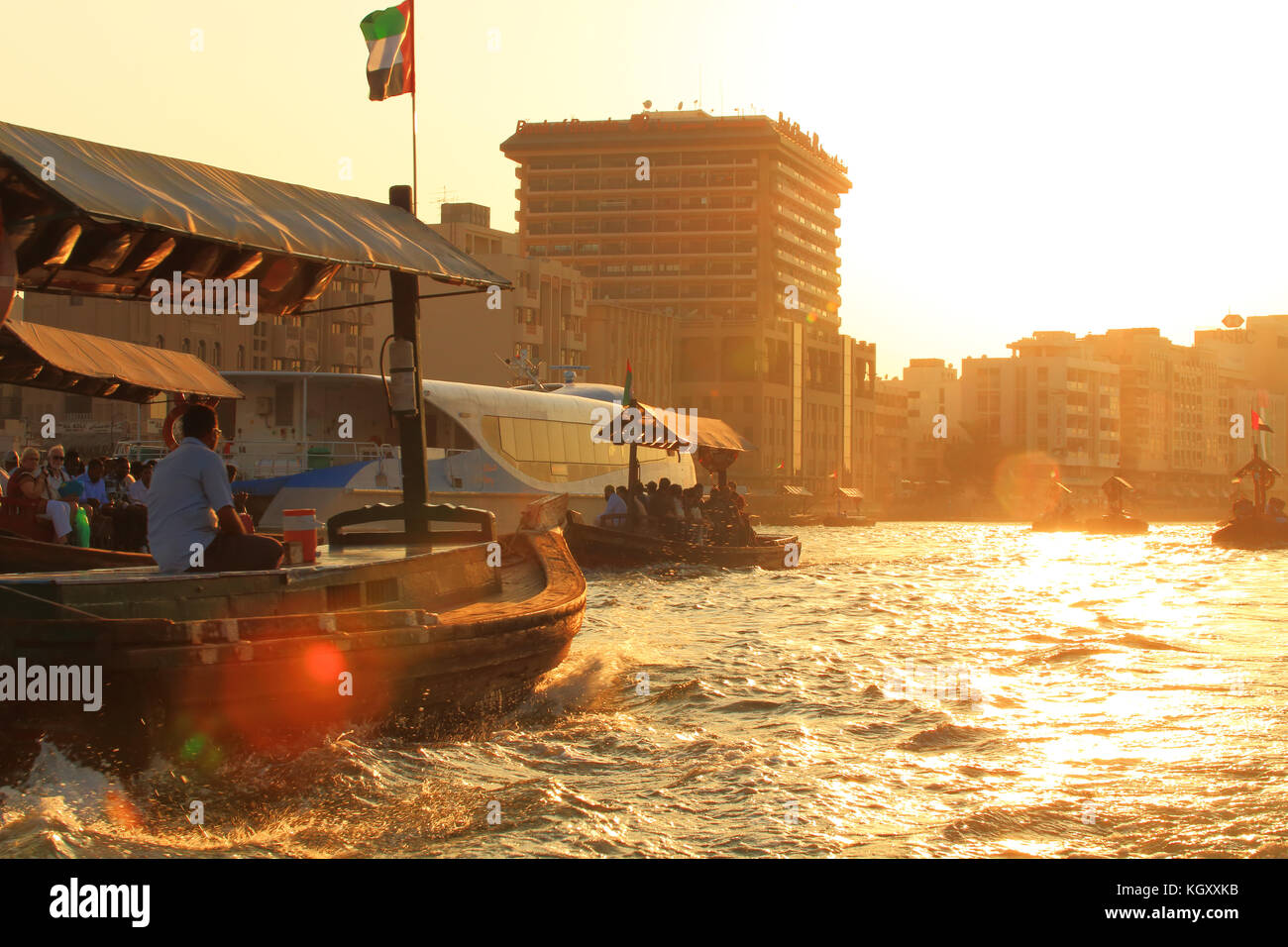 Dubai historic centre in the evening. Wooden tourist boats on the bay in Dubai at the sunset. Boats to old market in Dubai. Stock Photo
