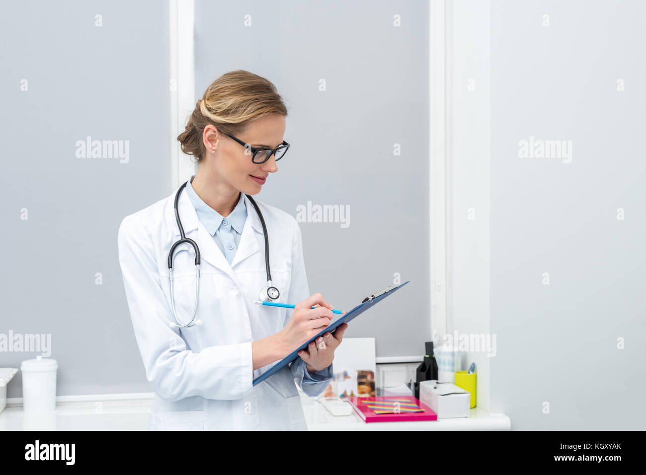 female doctor writing in clipboard Stock Photo - Alamy