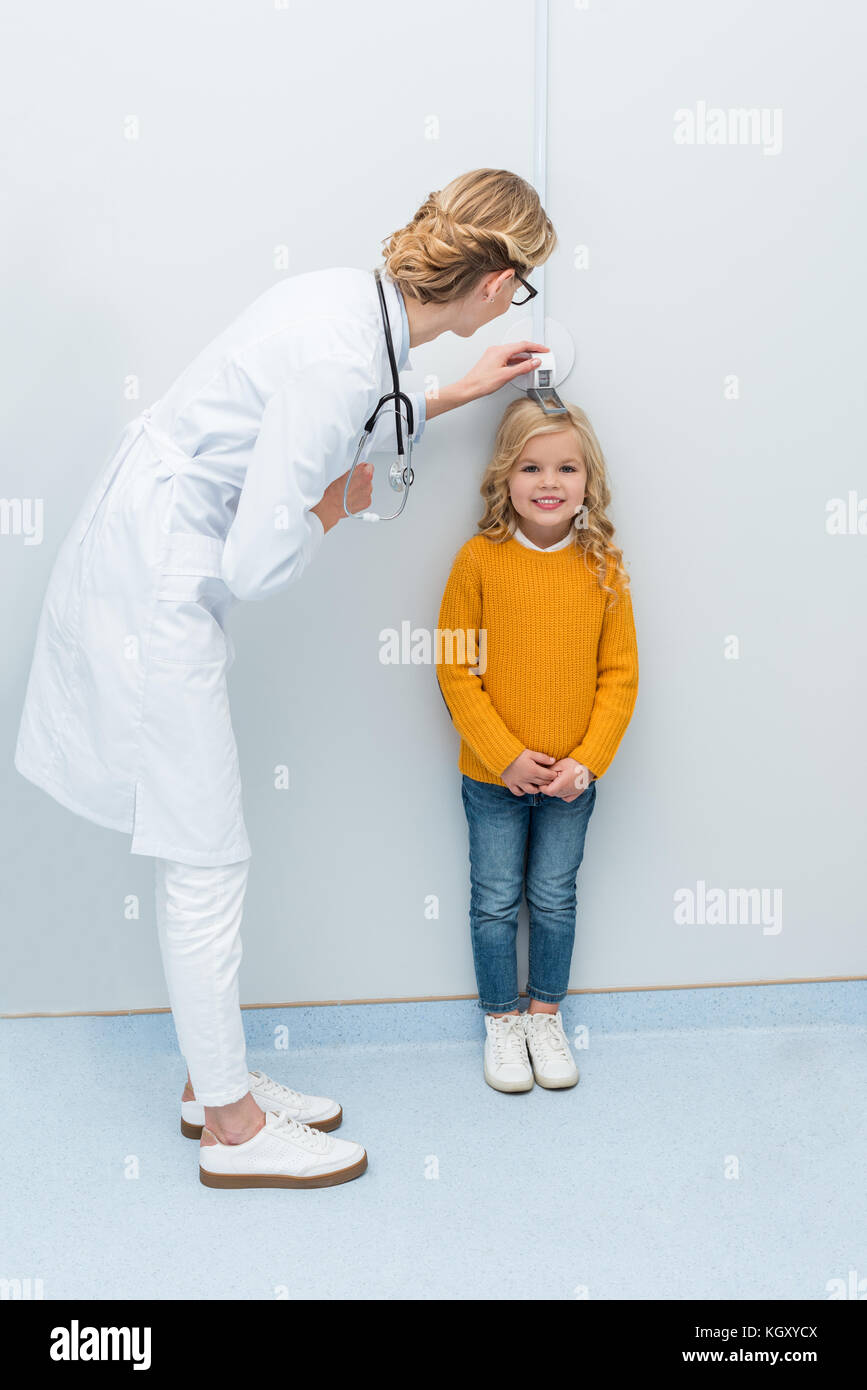doctor measuring height of little girl Stock Photo