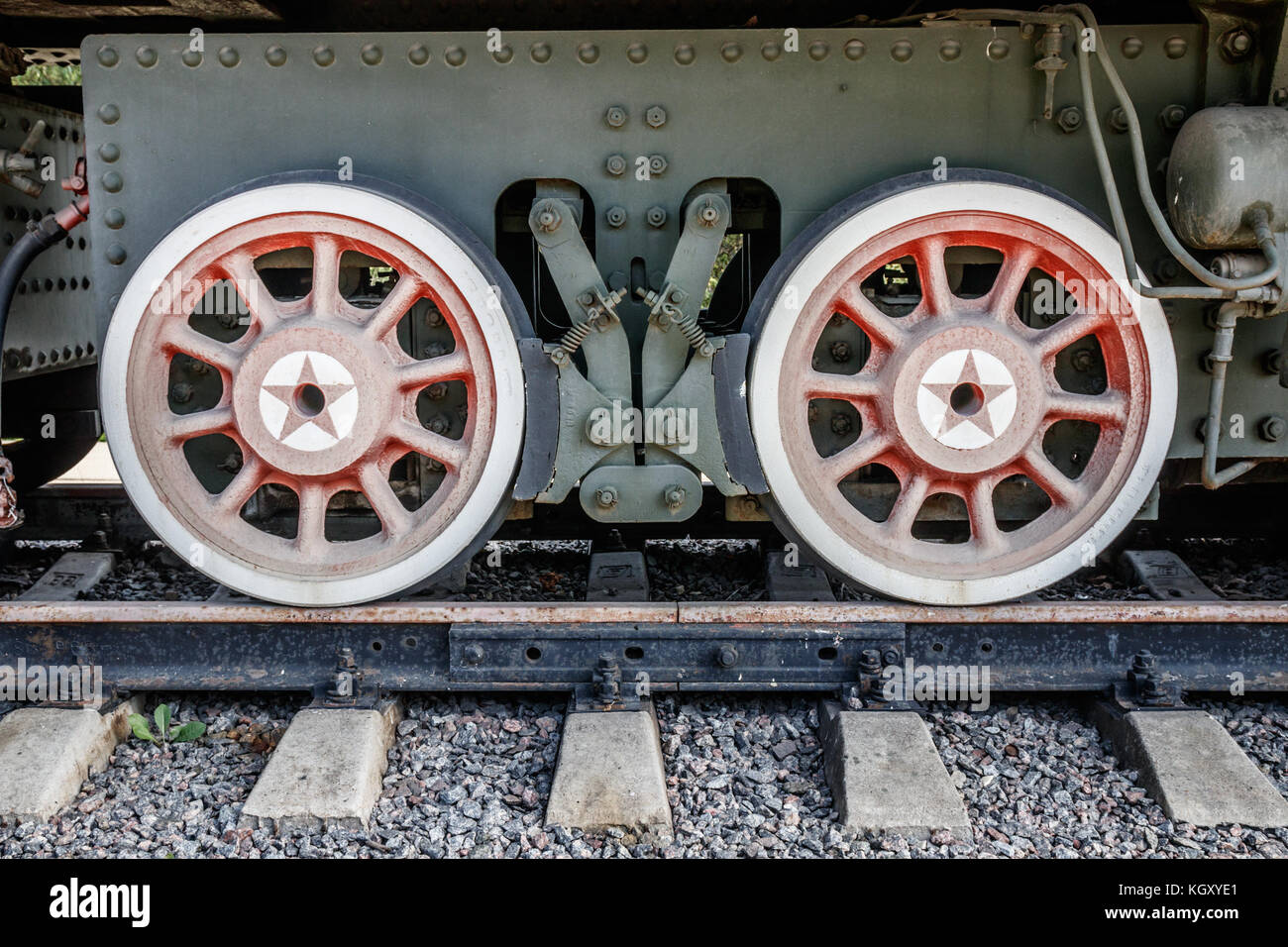 Green frame of a wagon with red spoke wheels on a track. Stock Photo
