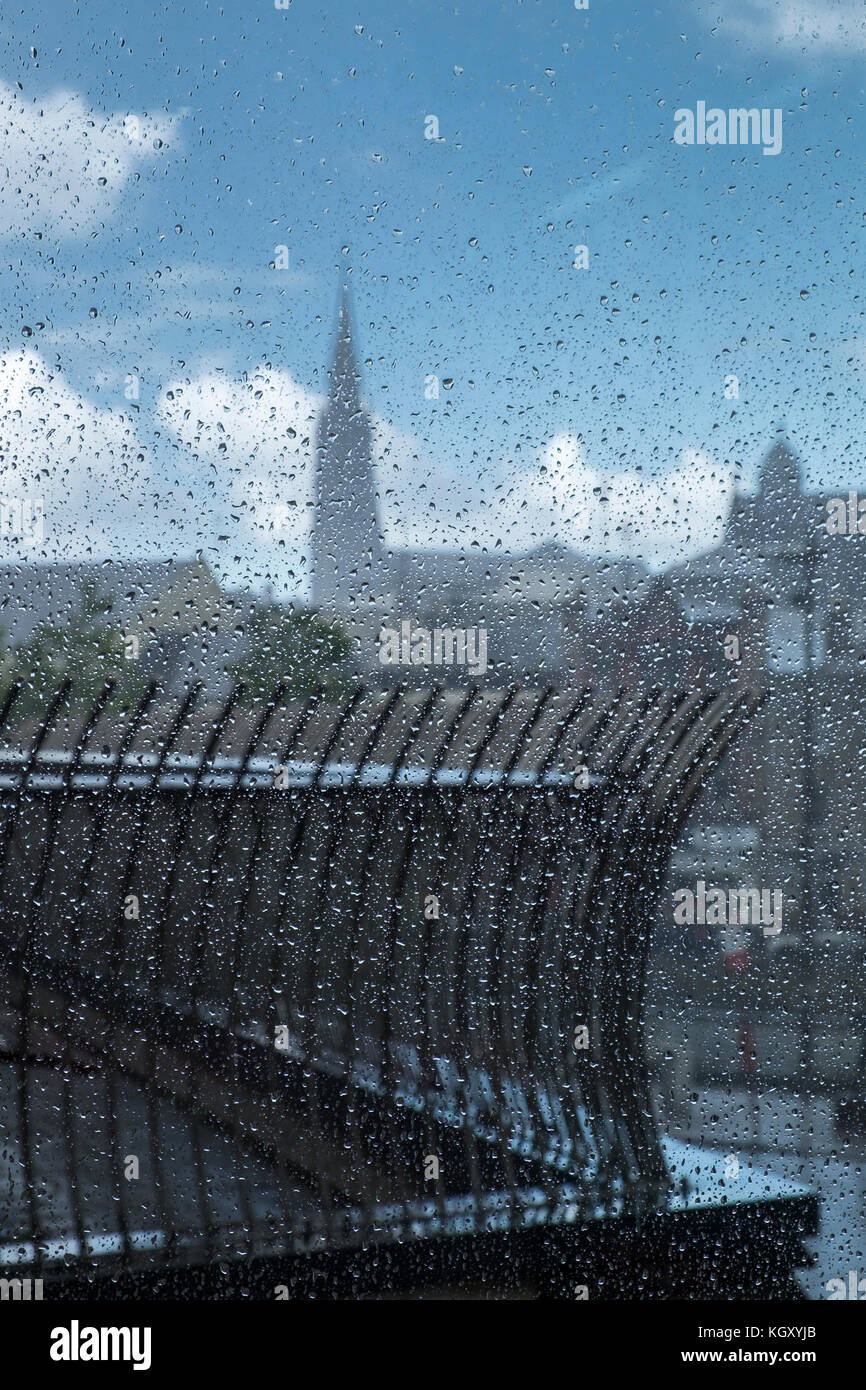 Rainy day with raindrops on glass window looking out to Drogheda town, railings and church steeple. Wet weather in County Louth, Ireland Stock Photo