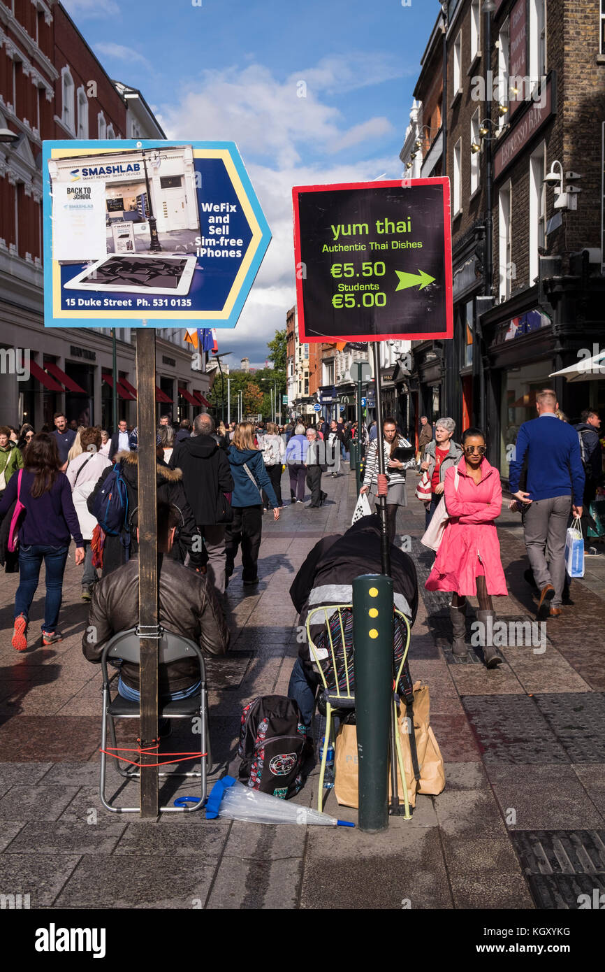 Street scenes on the corner of Grafton street and Duke Street, Dublin, pedestrians, shoppers, sandwich board advertising boards, on a sunny day, Irela Stock Photo