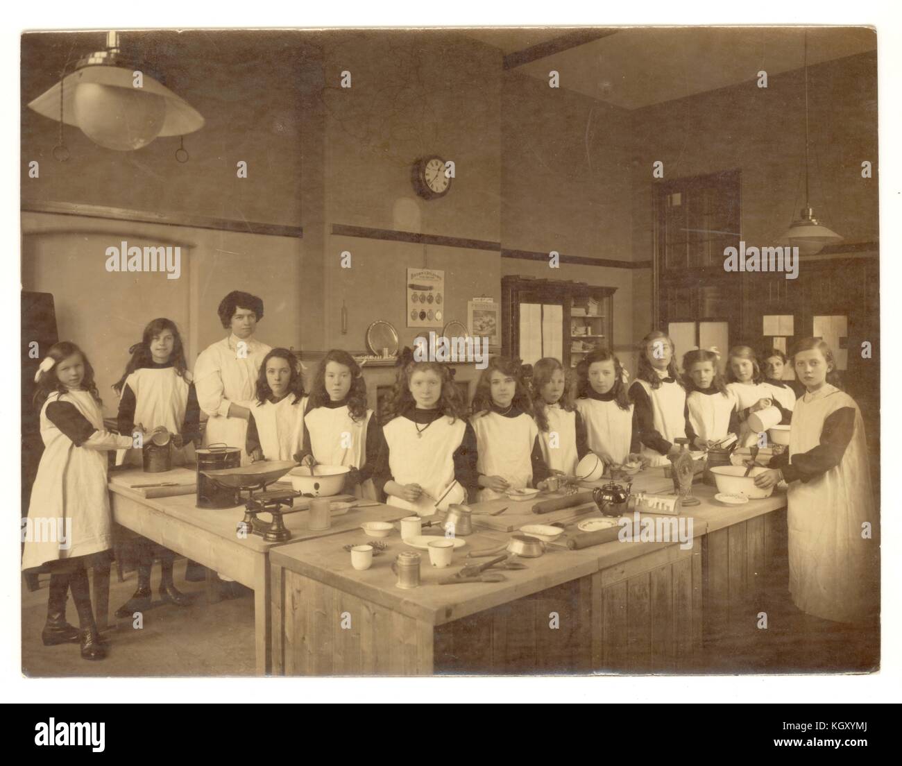 Original photograph of Edwardian girls in a Domestic Science class, learning baking and cookery in school kitchen, circa 1910, U.K. Stock Photo