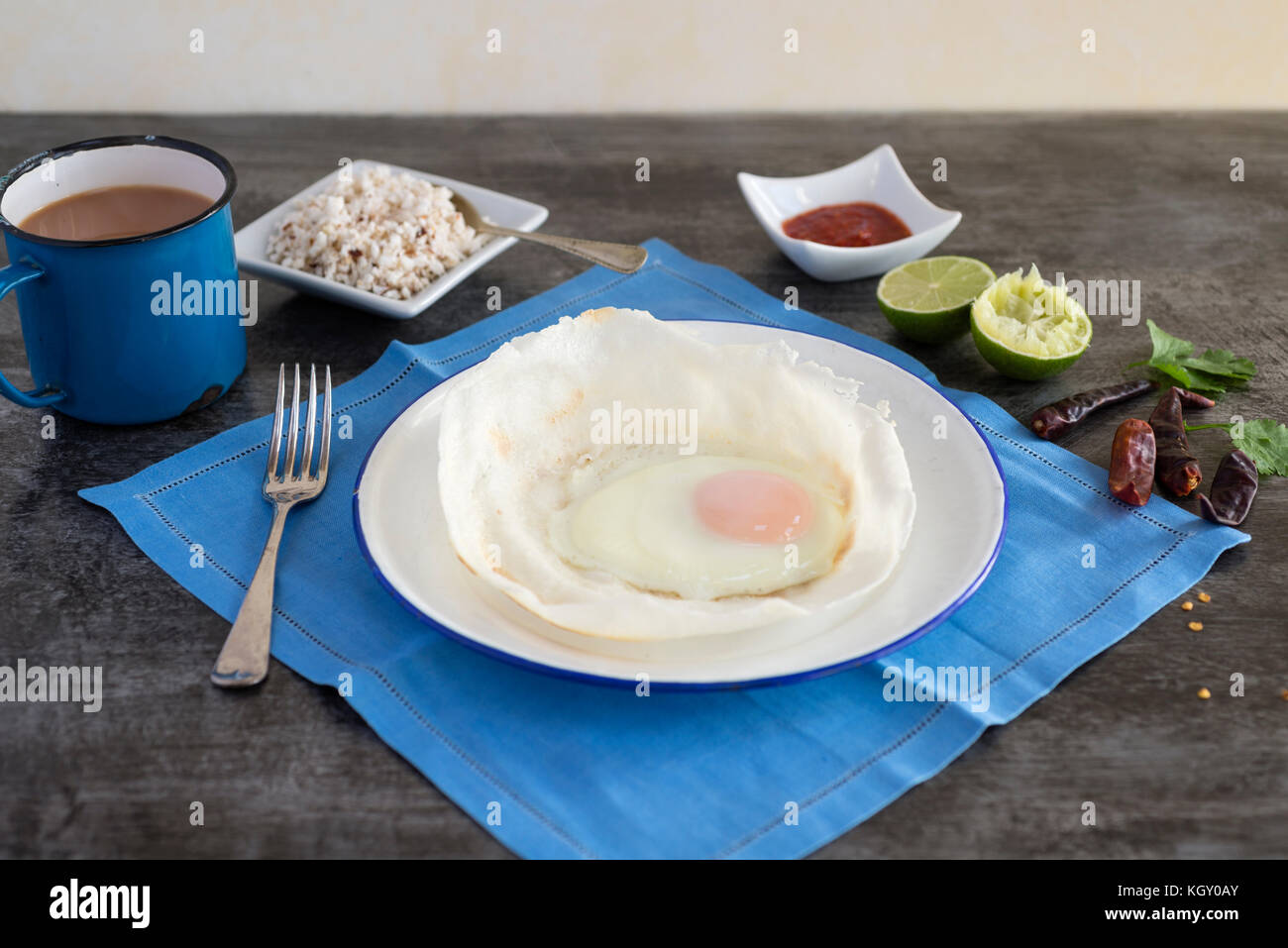 Sri Lankan hoppers with egg, served with coconut sambol and chilli. Stock Photo
