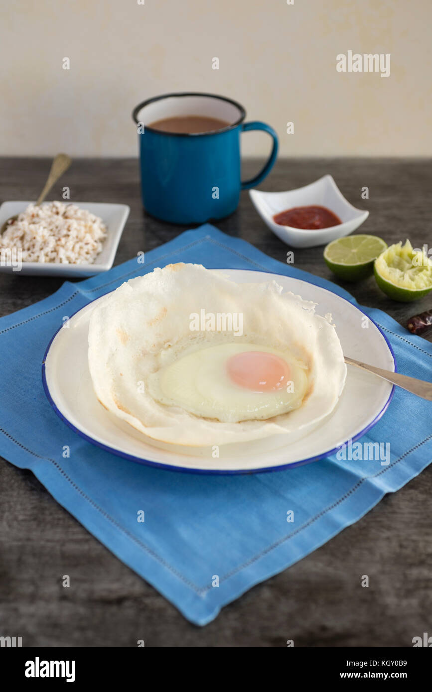Sri Lankan hoppers with egg, served with coconut sambol and chilli. Stock Photo