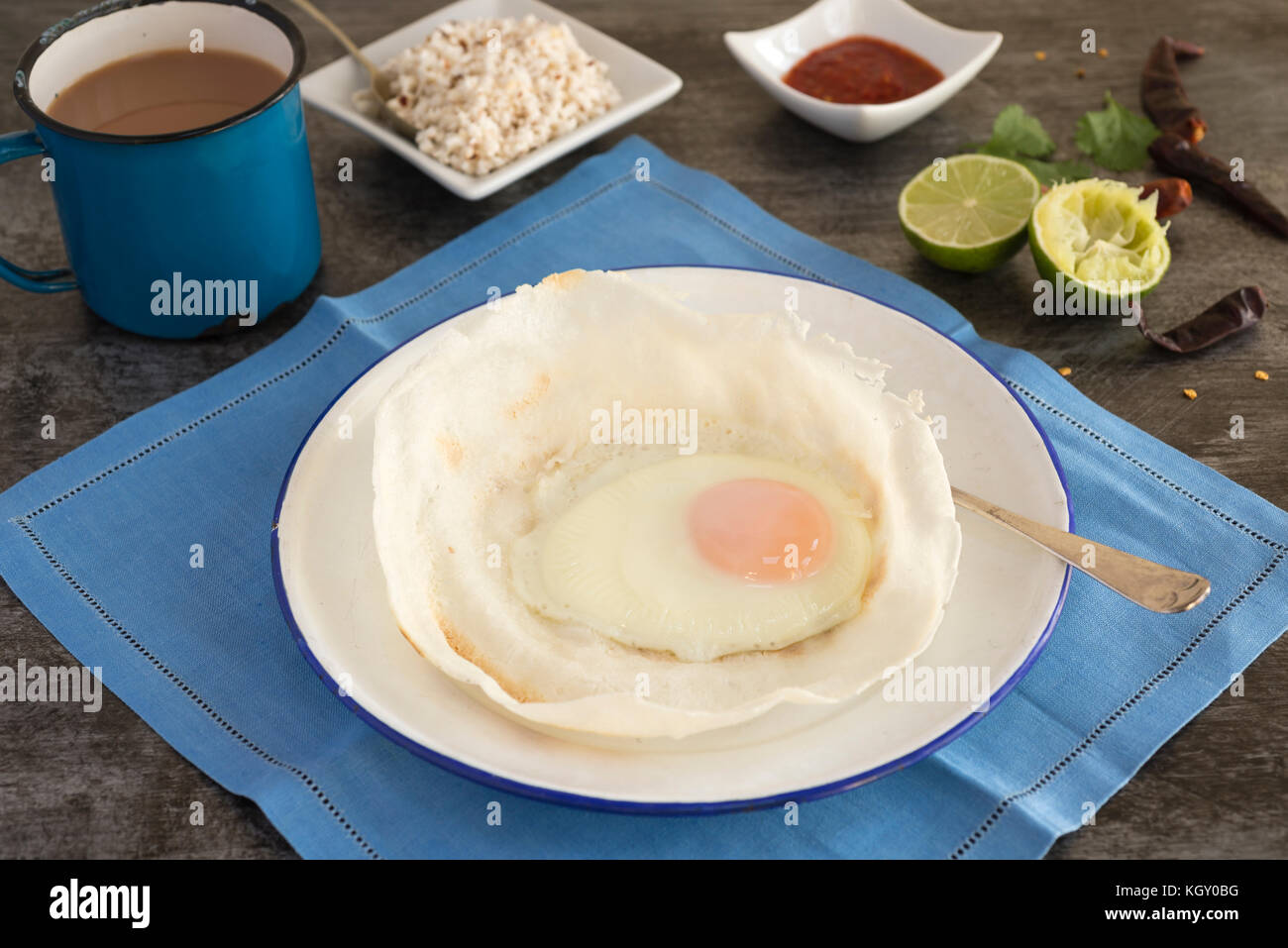 Sri Lankan hoppers with egg, served with coconut sambol and chilli. Stock Photo