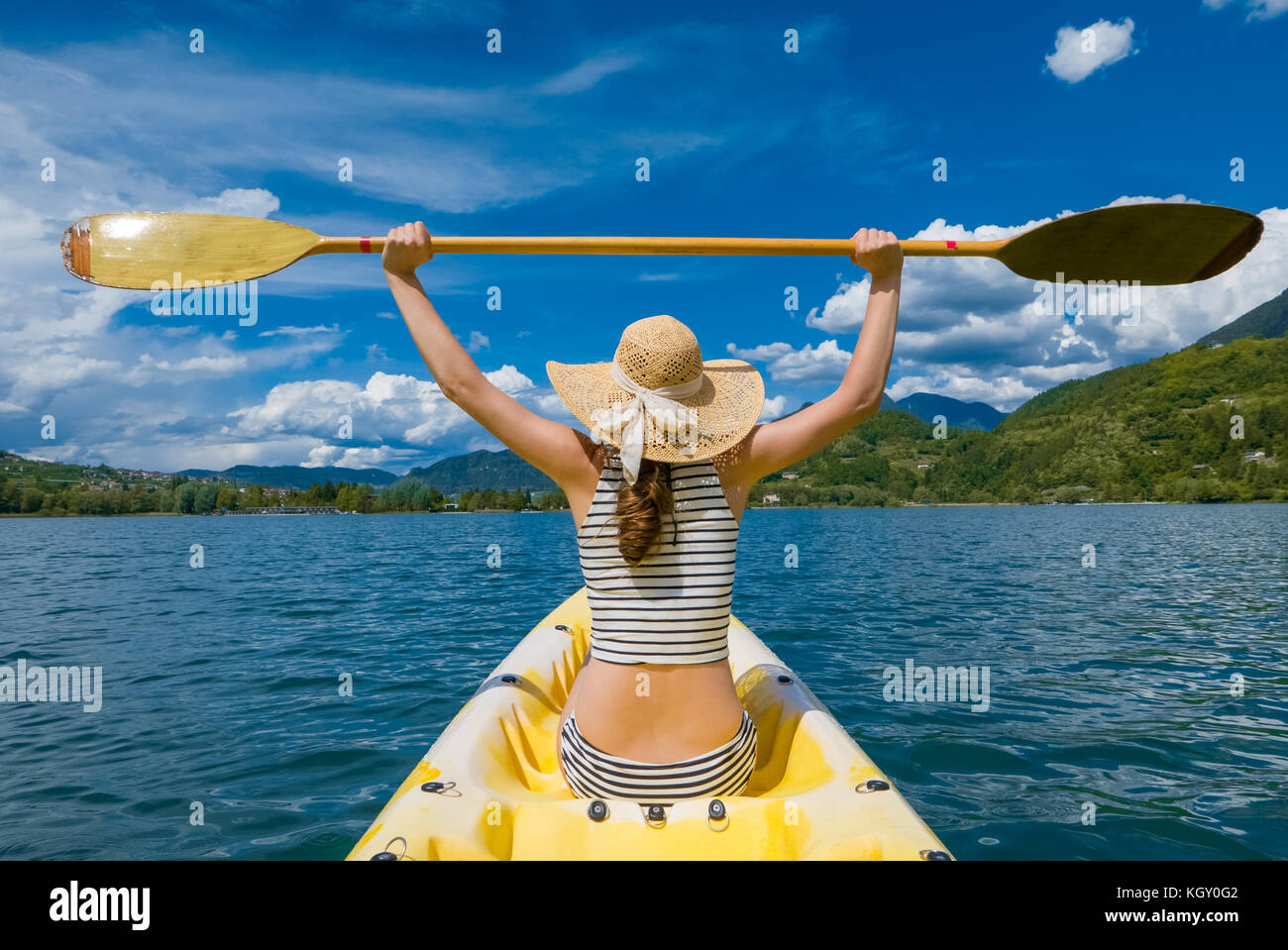 Young woman with long hair and hat kayaking in sun on lake Stock Photo -  Alamy