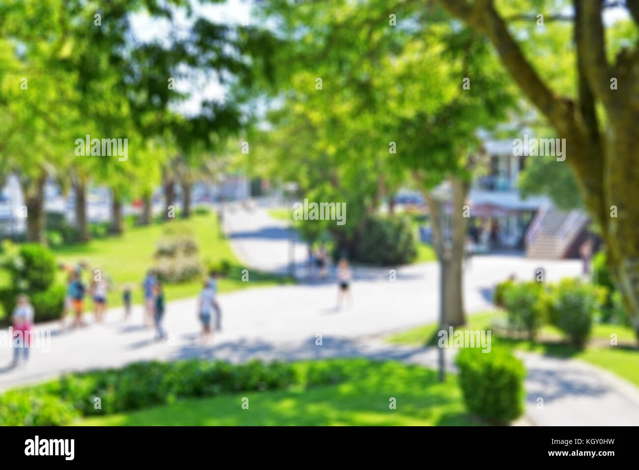 Blurred background of a public park with people walking in a beautiful