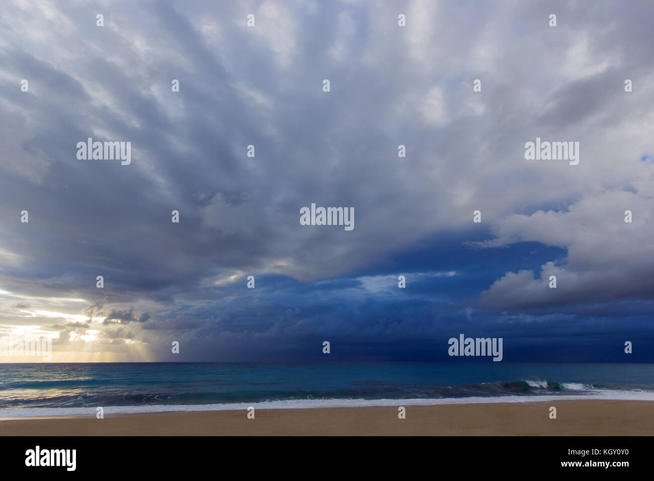 beach with blue sky and clouds with sunset on the left Stock Photo - Alamy