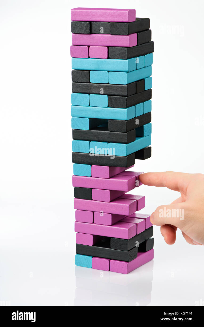 Taking on wooden brick from tower. Playing table game Stock Photo